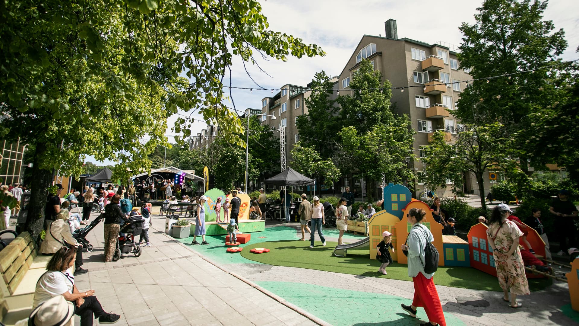 En grupp människor som står runt en lekplats.